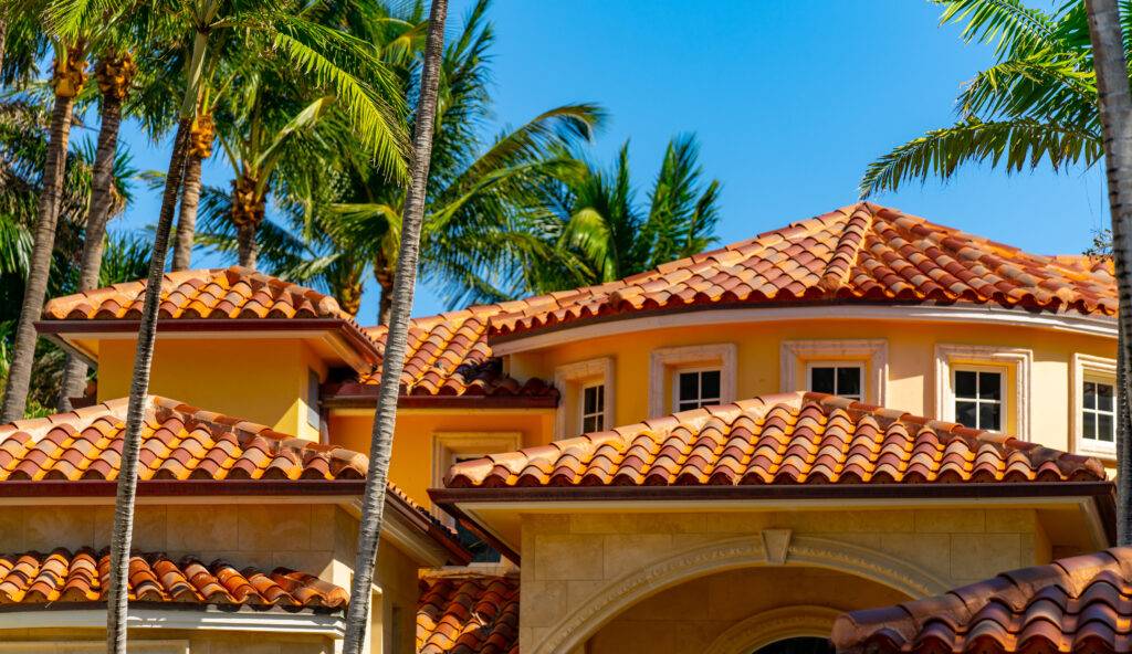 Barrel til roof top luxury Florida home with colorful palms and blue sky